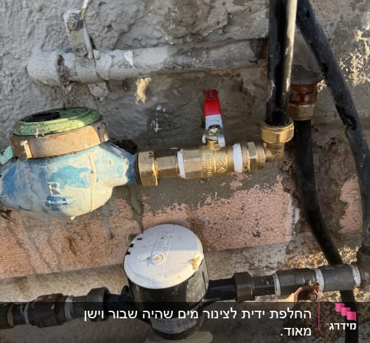 מד מים וצינורות על קיר חיצוני